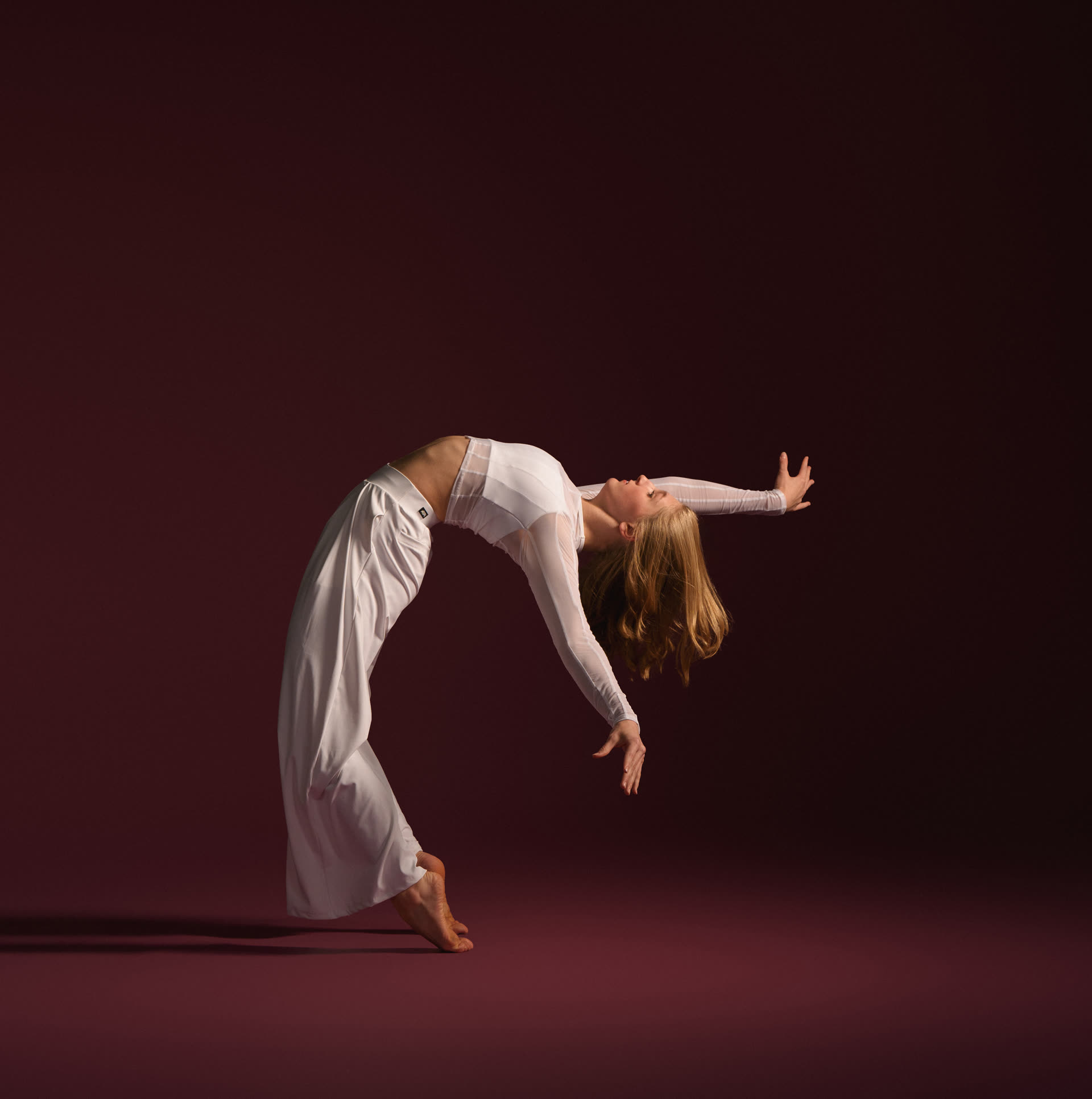 Dancer in white, full pose on stage