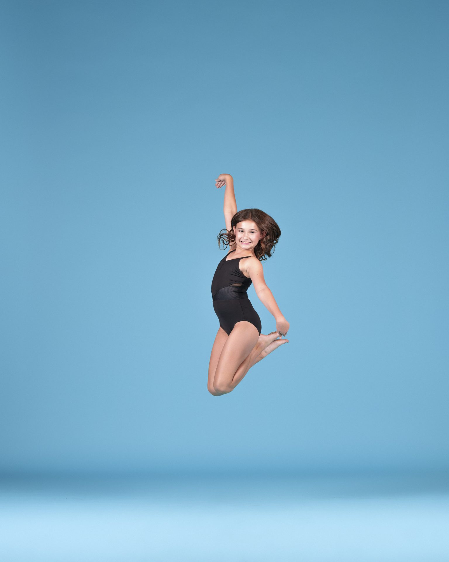 Young dancer mid-jump, full of joy