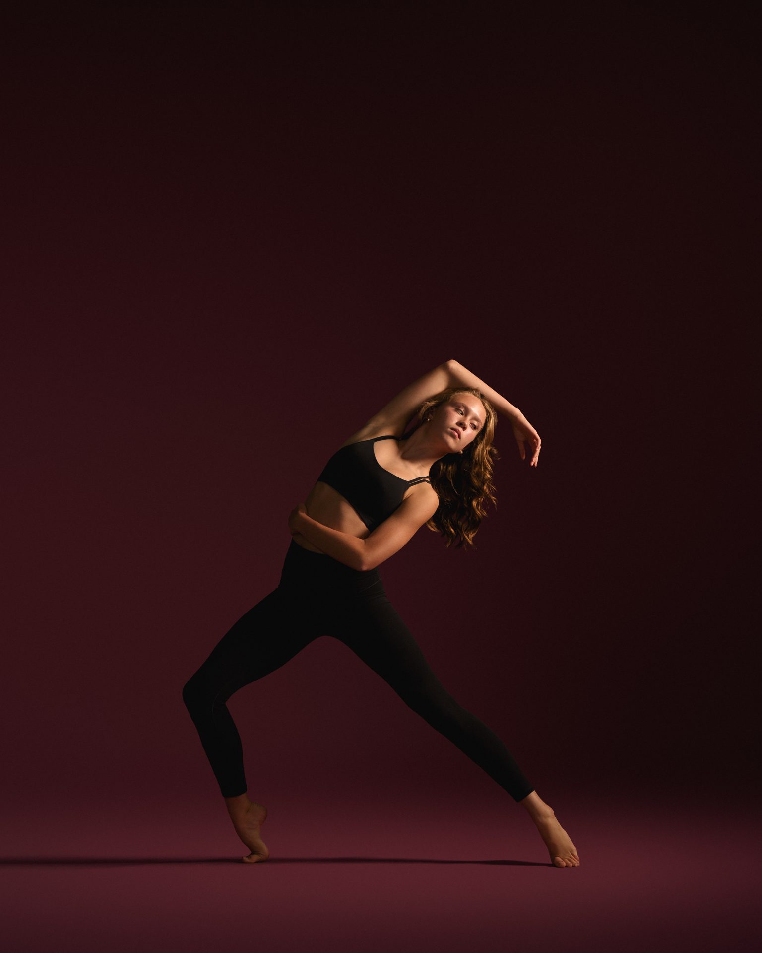 Dancer with arms overhead in a strong lunge